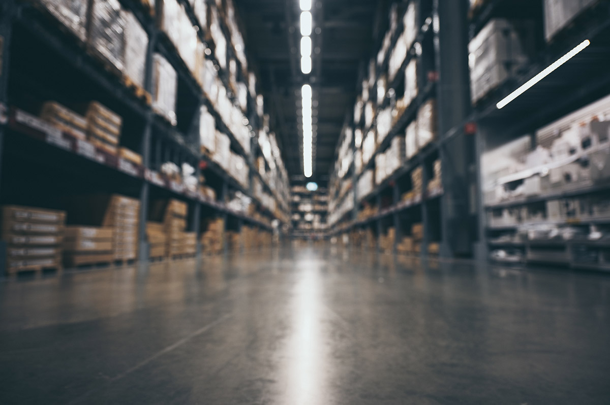 Warehouse workers in safety vests reviewing inventory